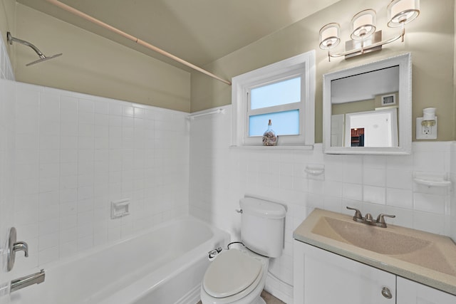 full bathroom with vanity, toilet, tiled shower / bath combo, and tile walls