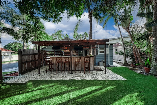 back of house with a yard, a patio, and an outdoor bar