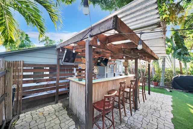 view of patio featuring an outdoor bar, a pergola, and a grill