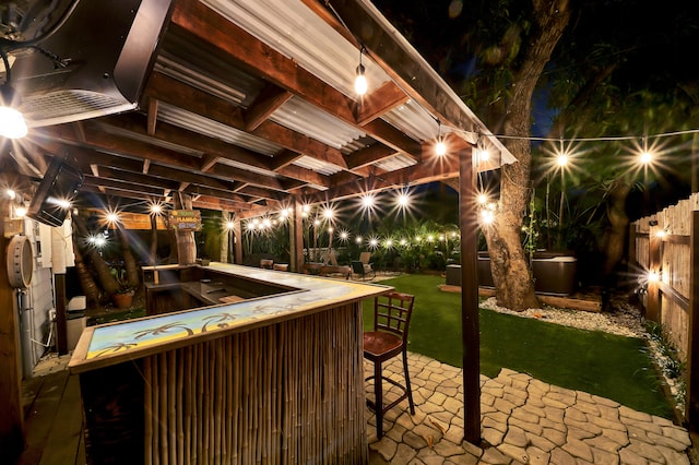 patio at twilight with a yard and an outdoor bar