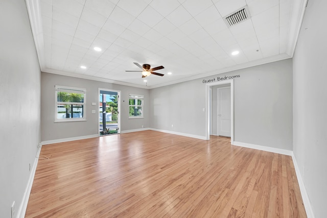 empty room featuring ornamental molding, light wood-type flooring, and ceiling fan