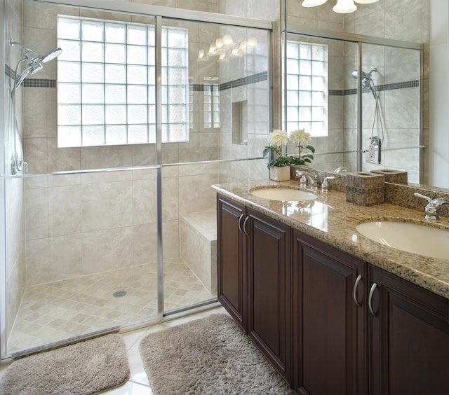 bathroom featuring a shower with door, vanity, and plenty of natural light