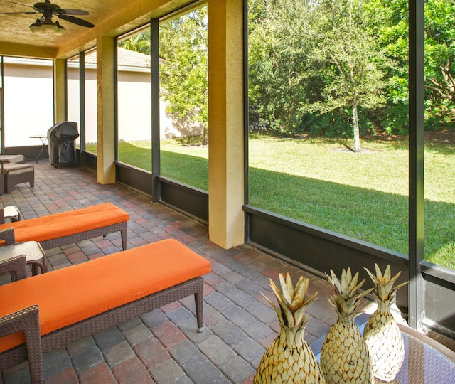 sunroom / solarium with a wealth of natural light and ceiling fan