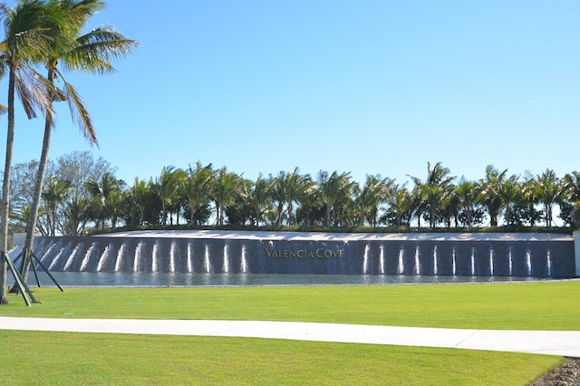 view of home's community with a lawn and a water view