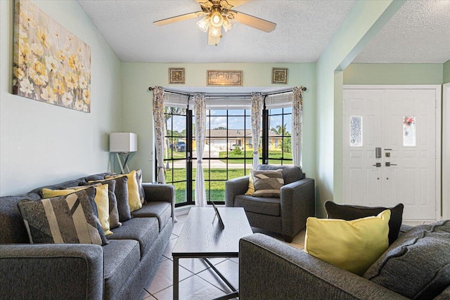 tiled living room with a textured ceiling and ceiling fan