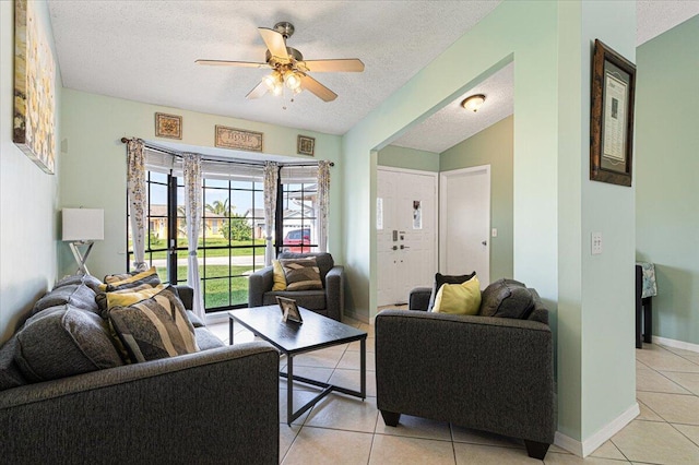 living room with ceiling fan, a textured ceiling, and light tile patterned floors