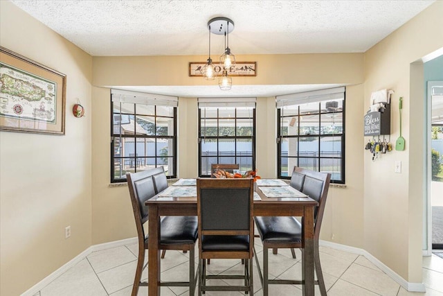 tiled dining area featuring a textured ceiling