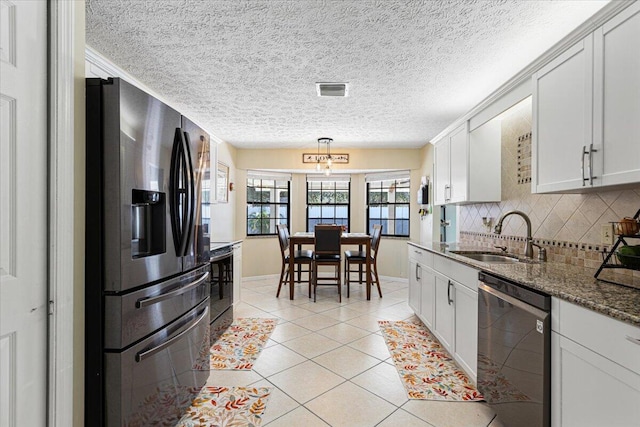 kitchen with decorative backsplash, white cabinetry, light tile patterned flooring, sink, and stainless steel appliances