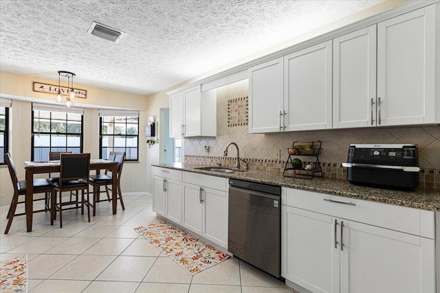 kitchen featuring black dishwasher, sink, white cabinetry, and dark stone countertops