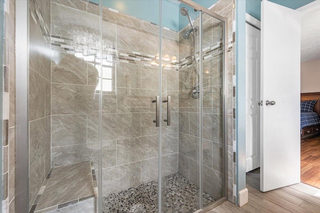 bathroom featuring wood-type flooring and an enclosed shower