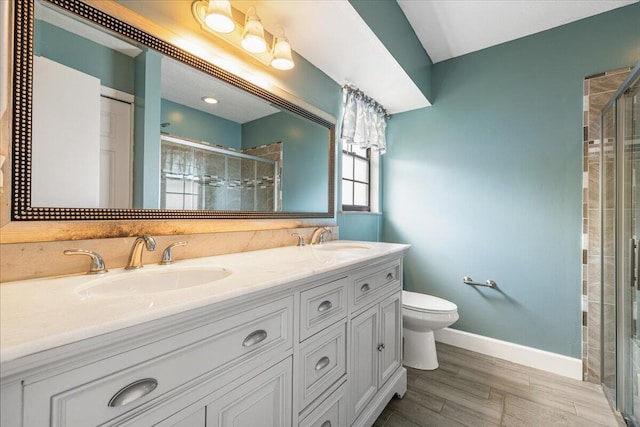 bathroom featuring vanity, toilet, a shower with door, and hardwood / wood-style floors