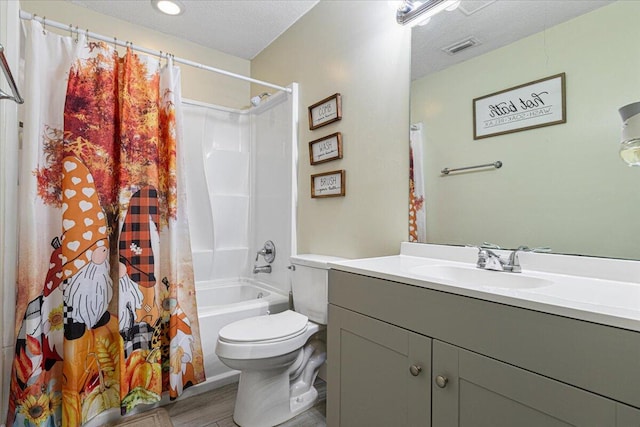 full bathroom featuring toilet, hardwood / wood-style floors, shower / tub combo with curtain, vanity, and a textured ceiling