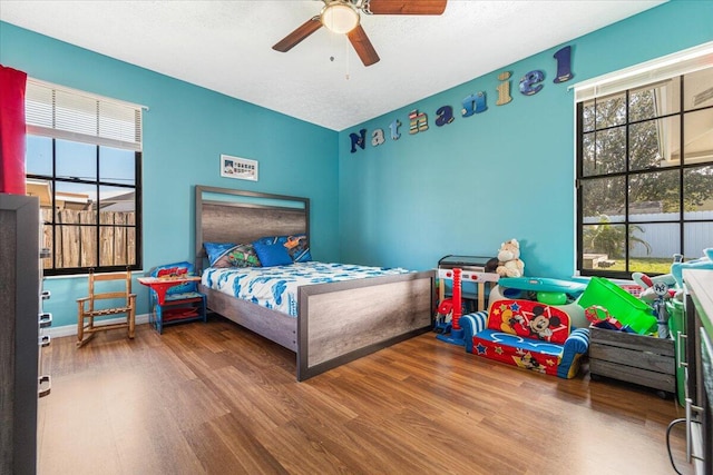 bedroom with hardwood / wood-style floors, a textured ceiling, and ceiling fan