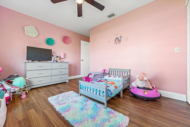 bedroom featuring dark wood-type flooring, ceiling fan, and a textured ceiling