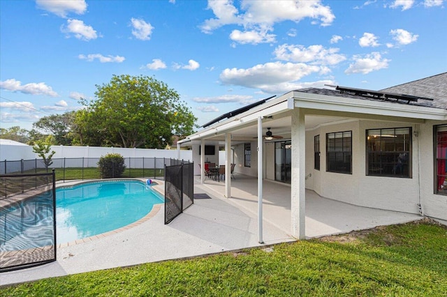 view of swimming pool featuring a patio area, a lawn, and ceiling fan