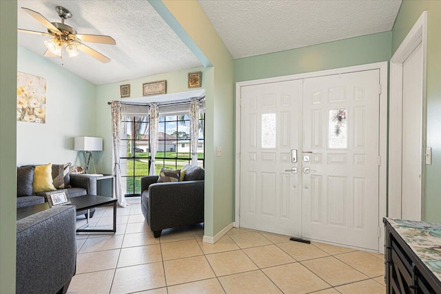 tiled entryway featuring ceiling fan, a textured ceiling, and lofted ceiling