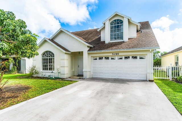 view of front of home with a garage and a front lawn