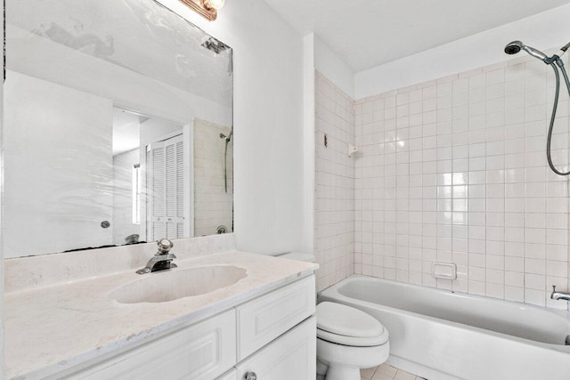 full bathroom featuring vanity, tiled shower / bath, toilet, and tile patterned floors