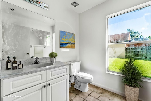 bathroom with vanity, tile patterned flooring, toilet, and plenty of natural light