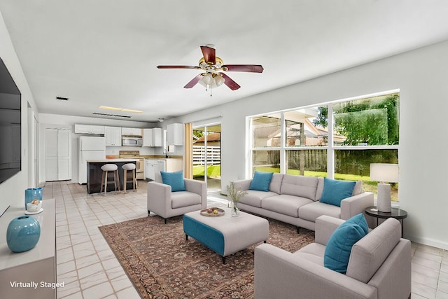 living room featuring ceiling fan and plenty of natural light