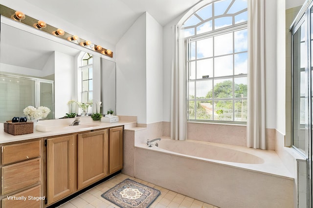 bathroom featuring vanity, independent shower and bath, tile patterned floors, and vaulted ceiling