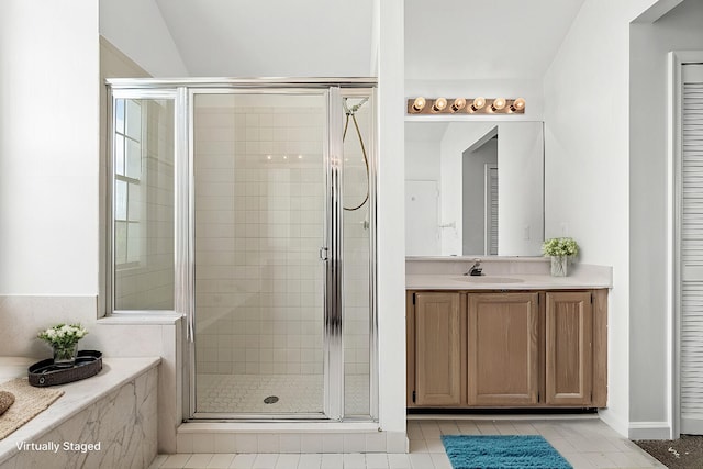 bathroom featuring vanity, vaulted ceiling, tile patterned flooring, and walk in shower