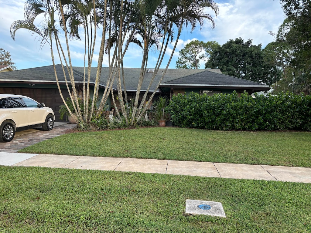 view of front of house with a front yard and a garage