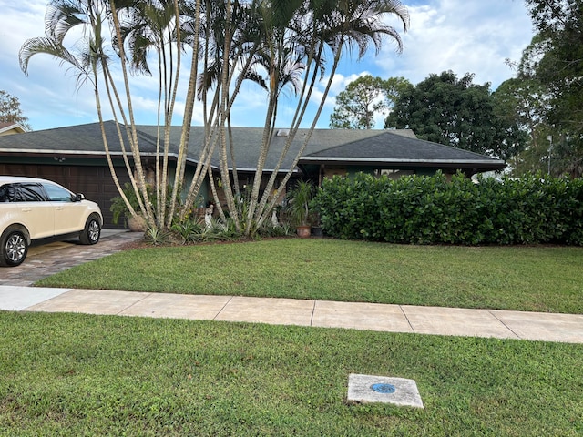 view of front of house with a front yard and a garage