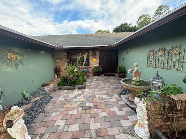 view of exterior entry featuring a patio