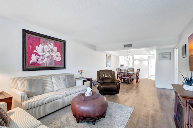 living room with light hardwood / wood-style floors and a textured ceiling