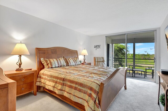 bedroom with access to outside and light colored carpet