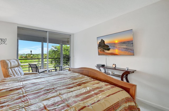 bedroom with access to outside, a textured ceiling, and carpet flooring