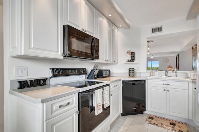kitchen with black appliances, white cabinets, hanging light fixtures, and light tile patterned floors