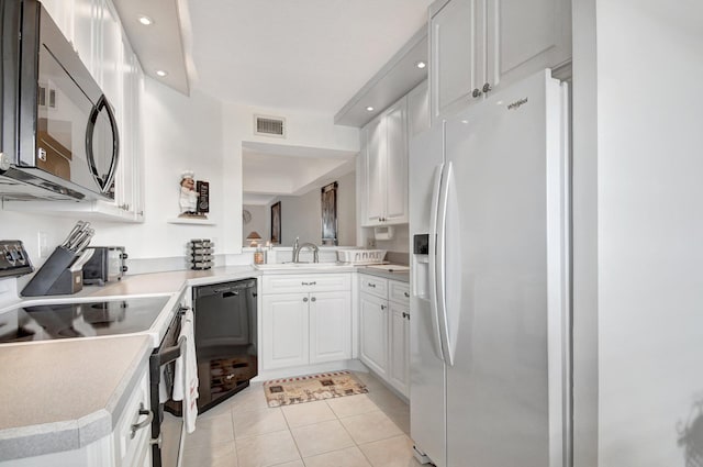 kitchen featuring kitchen peninsula, white cabinets, light tile patterned floors, black appliances, and sink