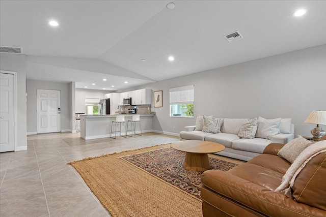 living room with light tile patterned floors and vaulted ceiling