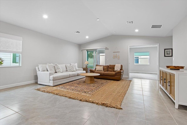 tiled living room with lofted ceiling and a wealth of natural light