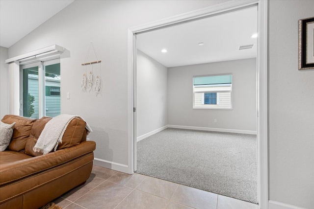 interior space with light carpet and lofted ceiling