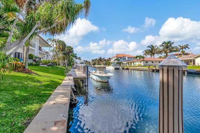 view of dock with a water view and a lawn