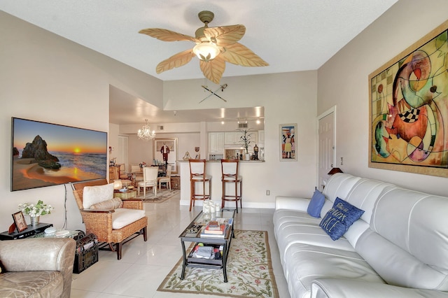 living room with light tile patterned floors and ceiling fan with notable chandelier