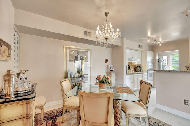 tiled dining room featuring a notable chandelier