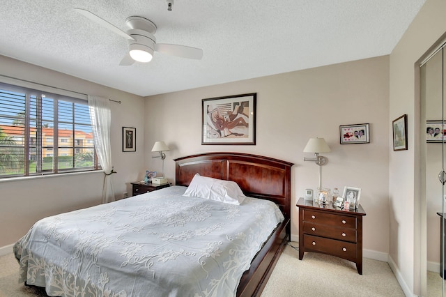 carpeted bedroom featuring a textured ceiling and ceiling fan