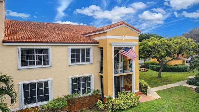 exterior space with a lawn and a balcony