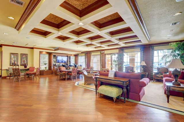 living room with light hardwood / wood-style flooring, beam ceiling, coffered ceiling, and crown molding