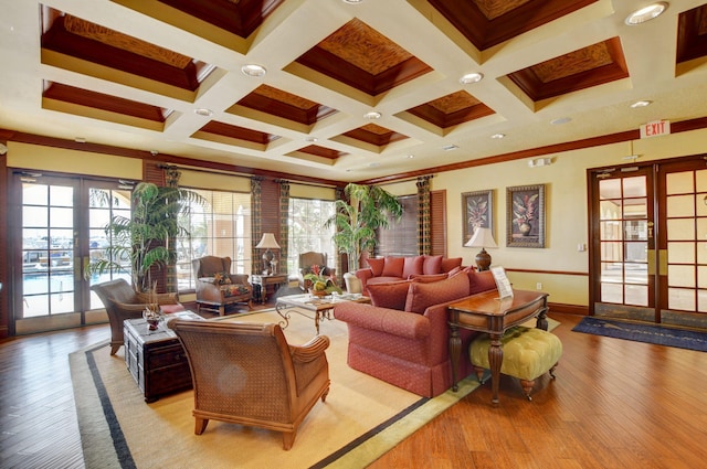 living room featuring french doors, crown molding, beam ceiling, and light wood-type flooring