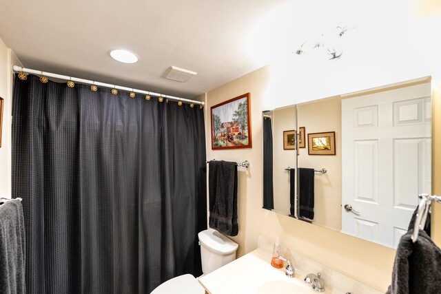 bathroom with vanity, toilet, and curtained shower