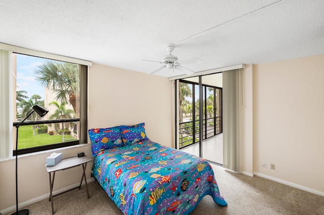 carpeted bedroom featuring a textured ceiling, multiple windows, and ceiling fan