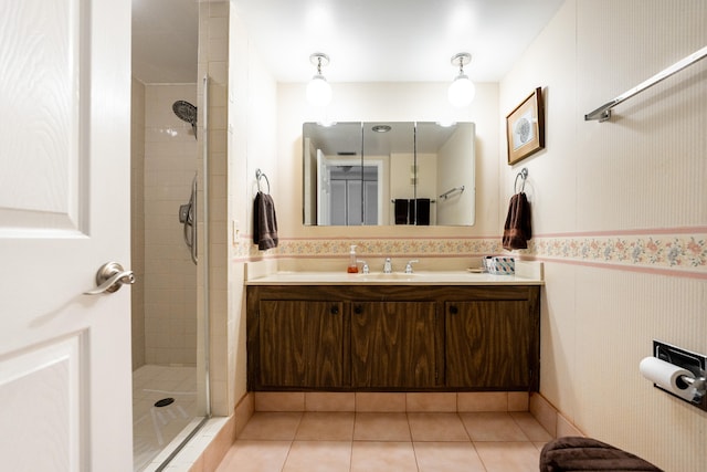 bathroom featuring vanity, a tile shower, and tile patterned flooring