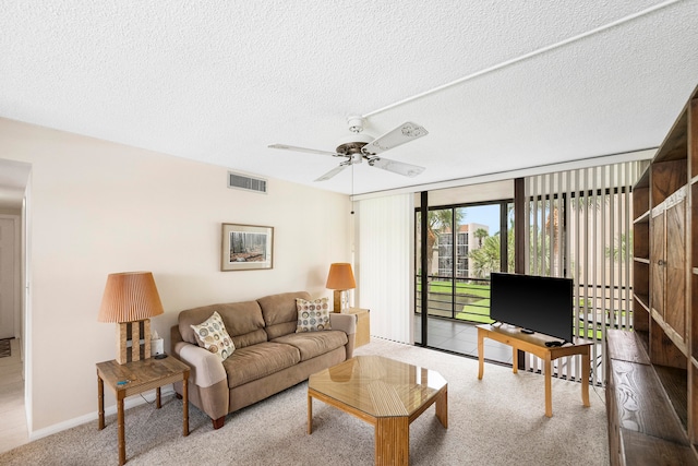 living room with carpet, a textured ceiling, and ceiling fan