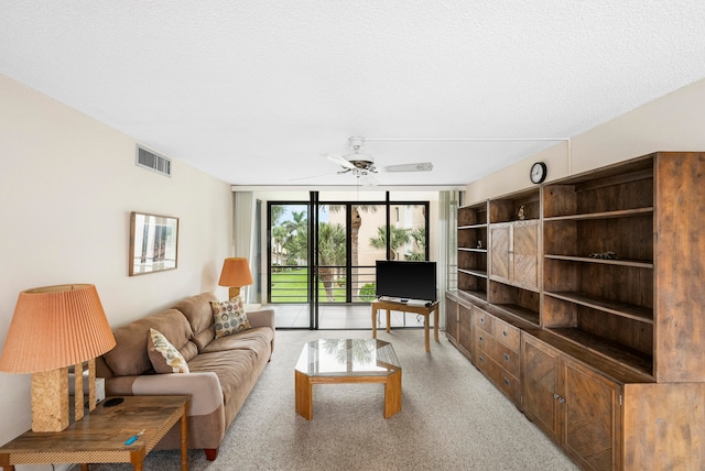 living room featuring a textured ceiling and ceiling fan