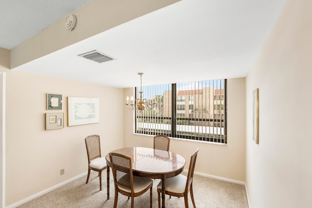 dining space featuring a chandelier and light colored carpet